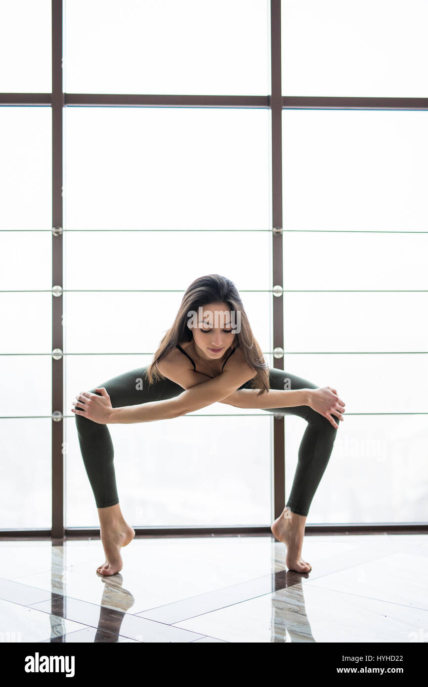 Beautiful yoga woman practice near window yoga room studio background. Yoga concept. Stock Photo