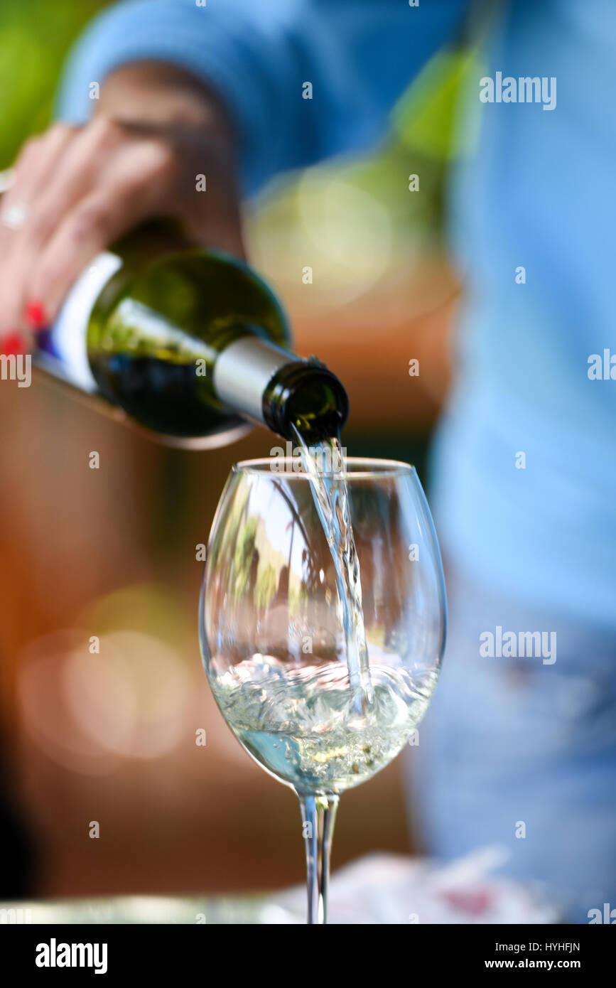 Hand pouring wine to a wine glass Stock Photo Alamy