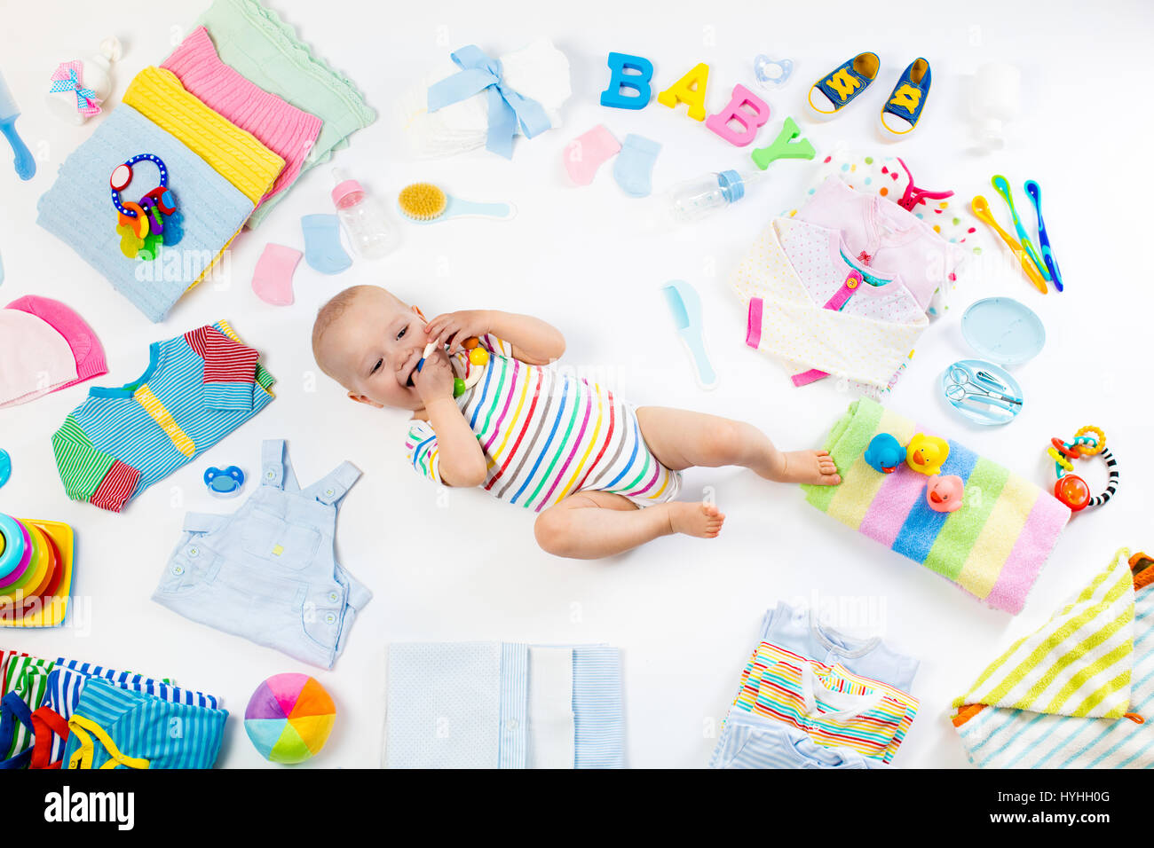 Baby on white background with clothing, toiletries, toys and health ...