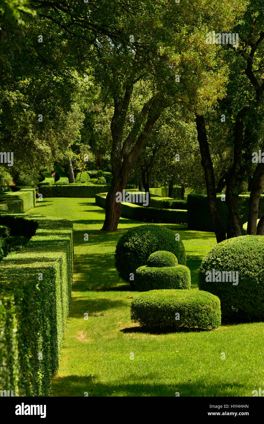 Portrait view of a manicured garden with lush summer foliage and hedges in the Dordogne, France. Stock Photo