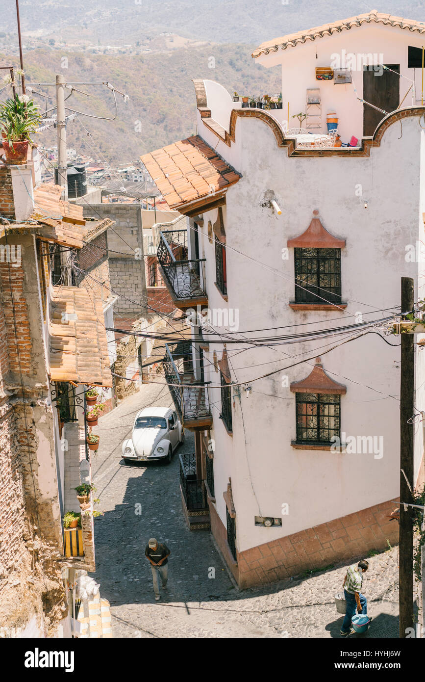 Volkswagen bug driving the winding streets of the old city of Taxco, Mexico. Stock Photo