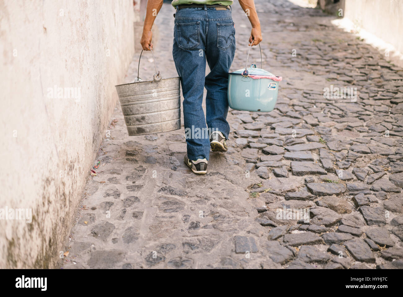 Man carries enamel pots filled with food to sell door to door in Taxco, Mexico. Stock Photo