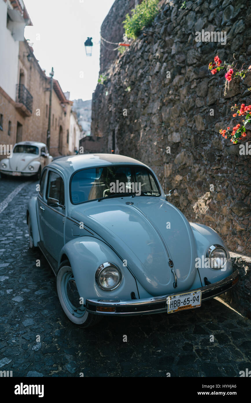 Volkswagen Bug driving through Taxco, Mexico. Old hilly town near Mexico city. Stock Photo