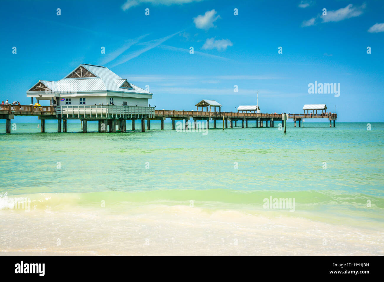 Beautiful Serene Turquoise waters near shoreline on the Gulf of Mexico at Clearwater Beach, FL. With Pier 60 with building on stilts in background Stock Photo