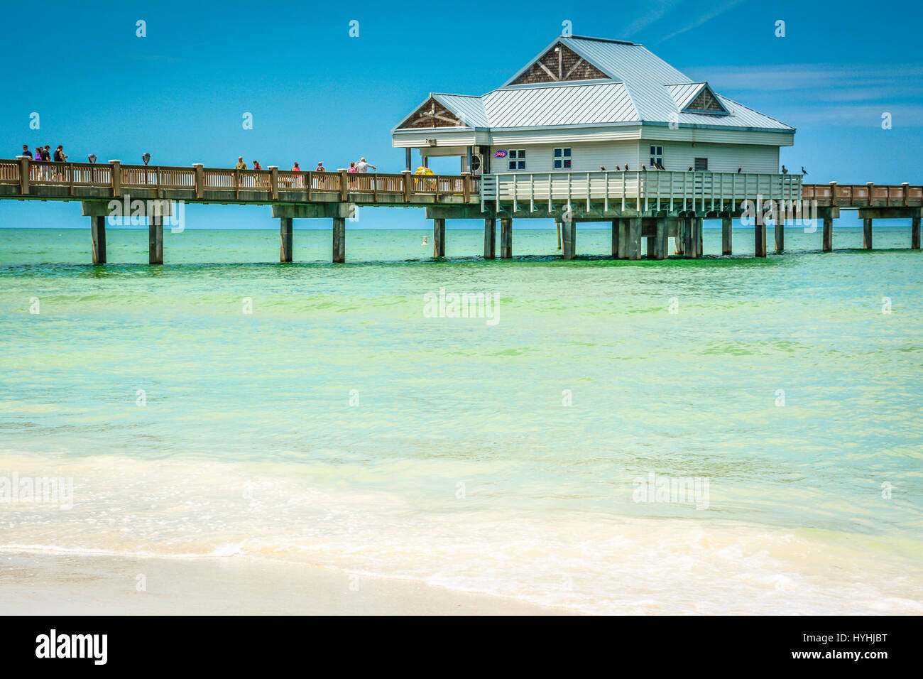 Beautiful Serene Turquoise waters near shoreline on the Gulf of Mexico at Clearwater Beach, FL. With Pier 60 with building on stilts in background Stock Photo