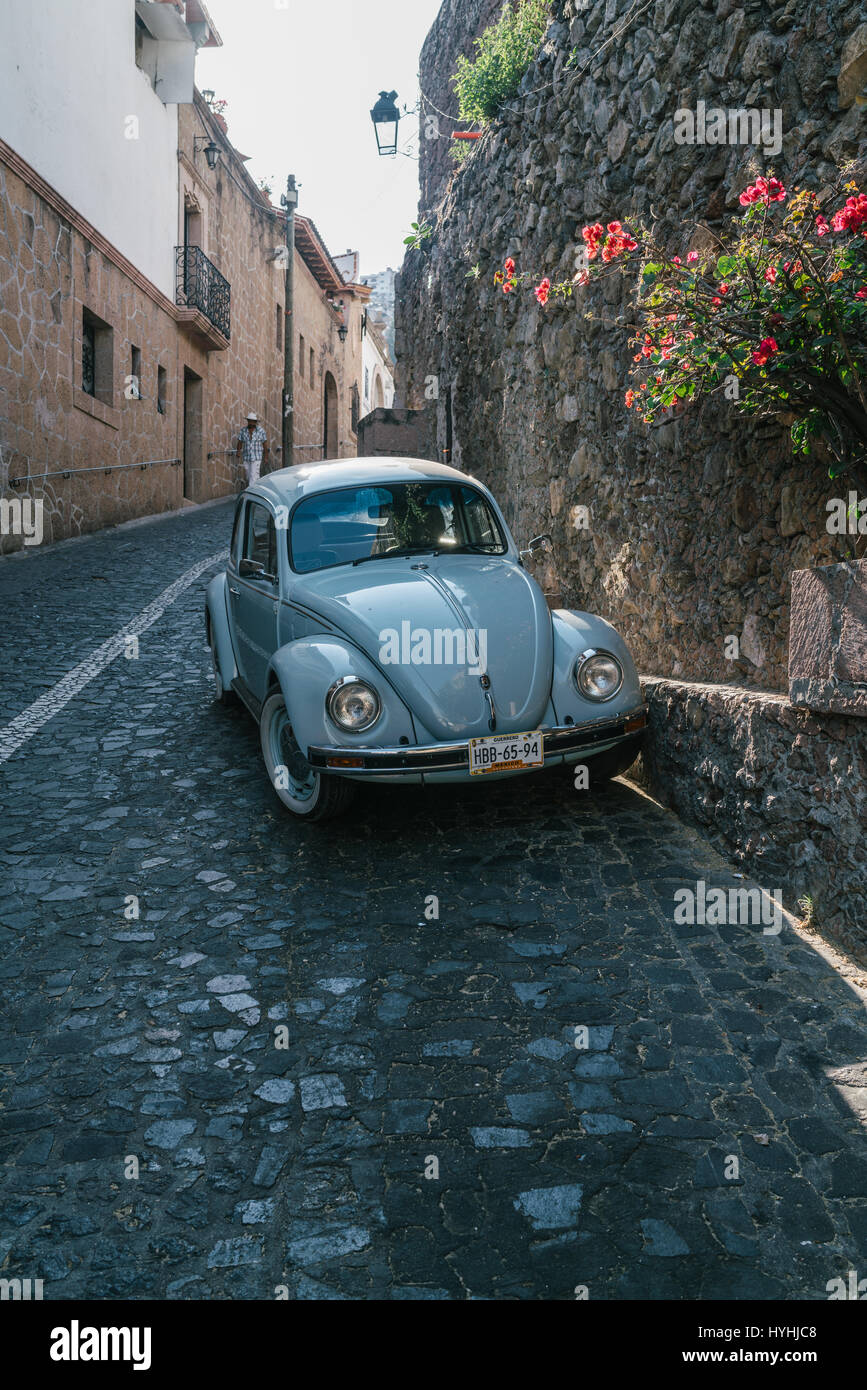 Volkswagen Bug driving through Taxco, Mexico. Old hilly town near Mexico city. Stock Photo