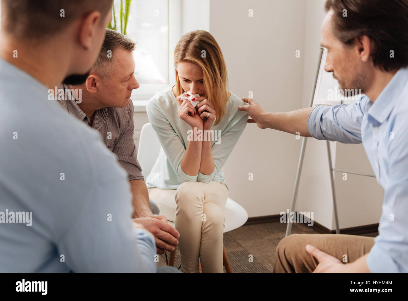 Disappointed woman putting her elbows on the left leg Stock Photo - Alamy