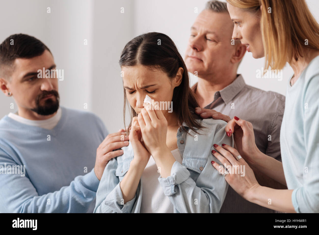Three coworkers feeling pity for their colleague Stock Photo