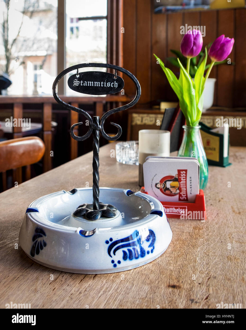 Berlin, Mitte, Zum Biermichel Traditional German Corner pub interior, typical Local bar. table with beer, flowers, ashtray & stammtisch sign Stock Photo