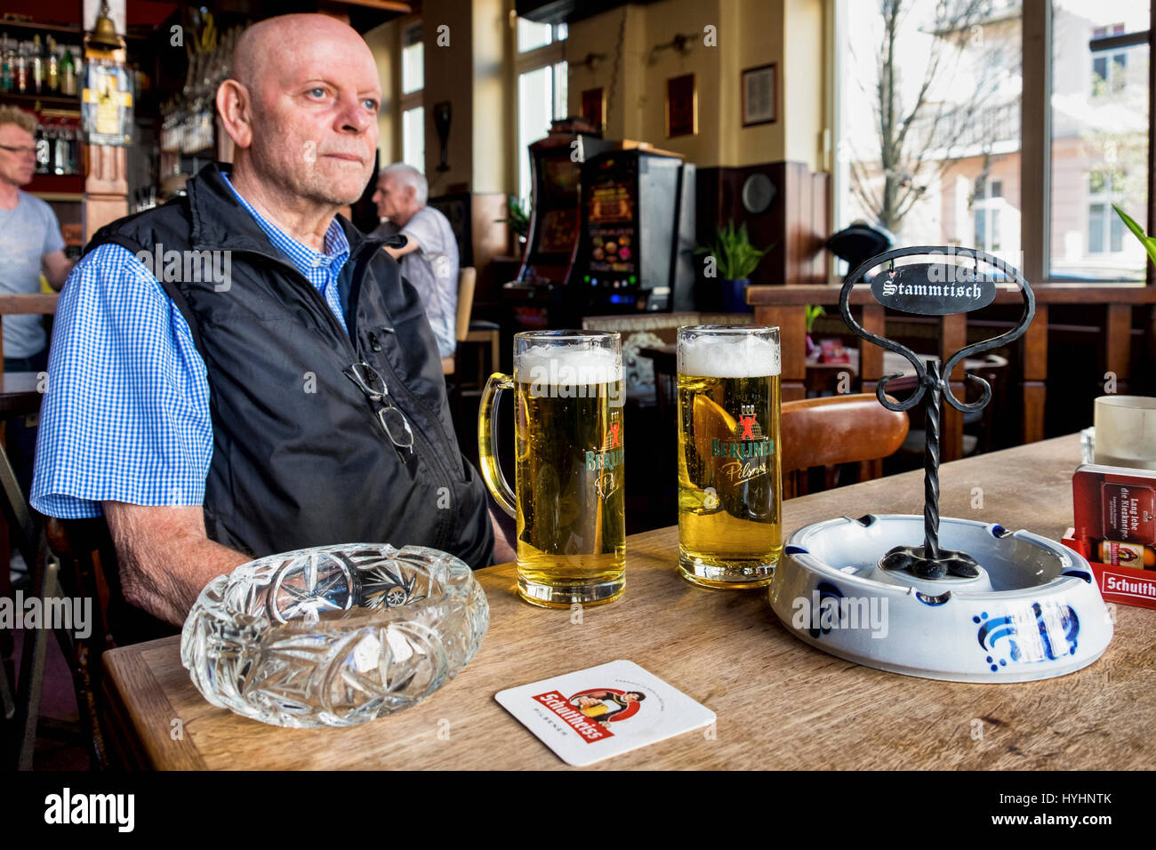 Berlin, Mitte, Zum Biermichel Traditional German Corner pub interior,Senior elderly man drinking beer in typical Local bar.Table with stammtisch sign. Stock Photo