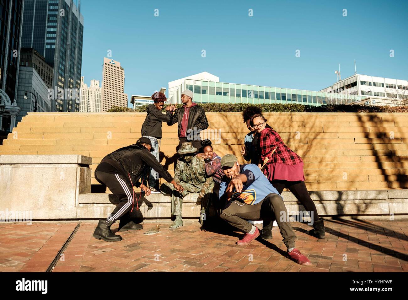 Portrait of a group of young african american teens posing downtown Atlanta with a statue Stock Photo