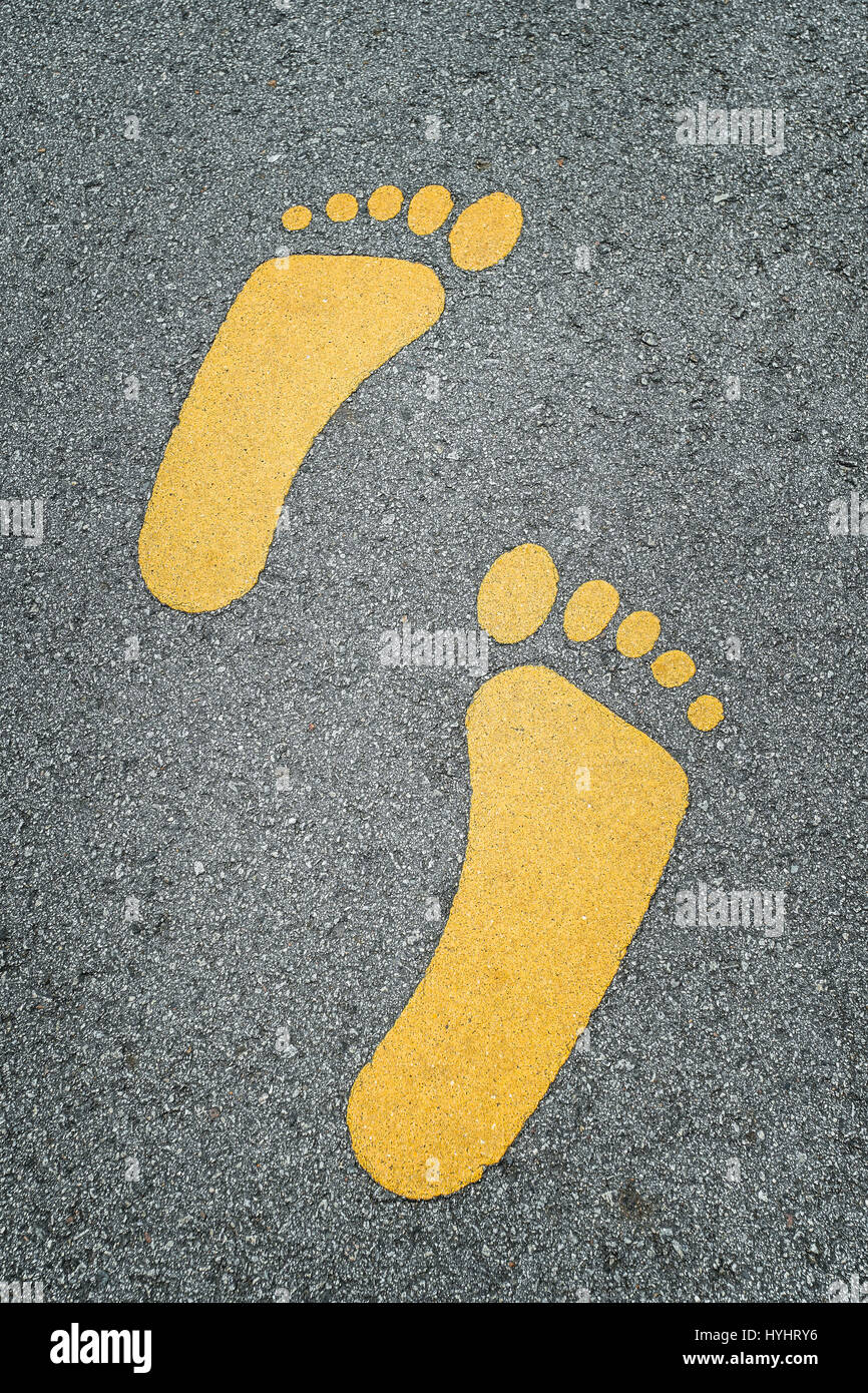 Closed up shot Foot sign on asphalt road Stock Photo