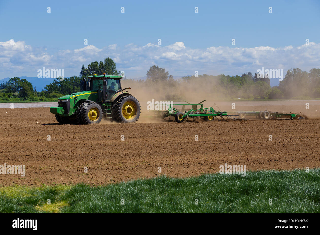 ALBANY, OR - MAY 7, 2015: John Deere commercial tractor plowing a field ...