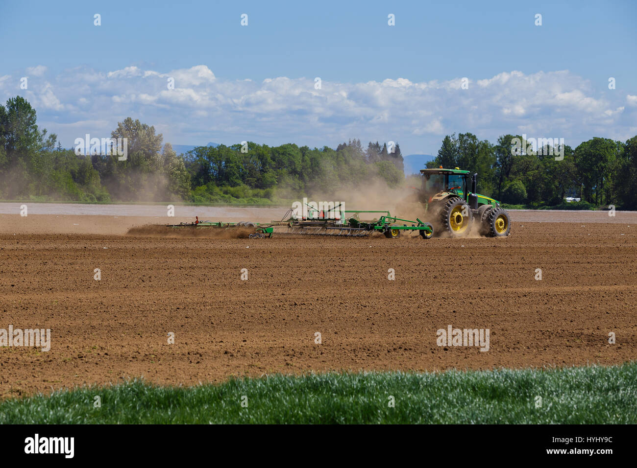 ALBANY, OR MAY 7, 2015 John Deere commercial tractor plowing a field