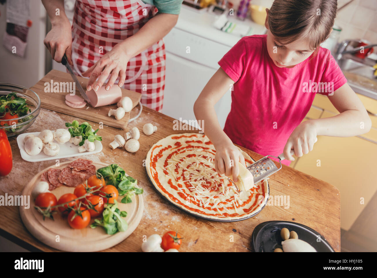 Mother and daughter preparing pizza in the kitchen Stock Photo