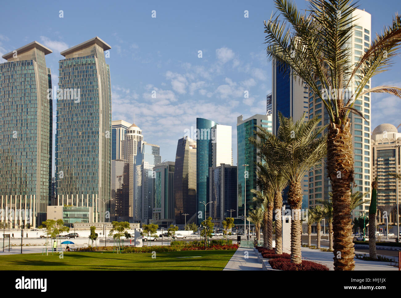 DOHA, QATAR - FEBRUARY 17, 2016: The high-rise district of Doha, seen from the road through the recently completed Hotel Park, and date palms in the f Stock Photo