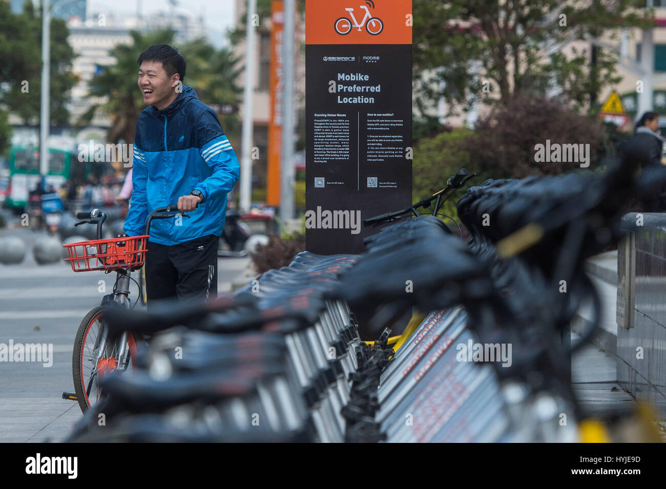 Kunming, China's Yunnan Province. 5th Apr, 2017. A man prepares to leave after unlocking a shared bicycle in Kunming, capital of southwest China's Yunnan Province, April 5, 2017. According to a report from Beijing-based BigData Research, by the end of 2016, there were 18.86 million users of shared bicycles, and the number is expected to expand to 50 million by the end of this year. Credit: Hu Chao/Xinhua/Alamy Live News Stock Photo