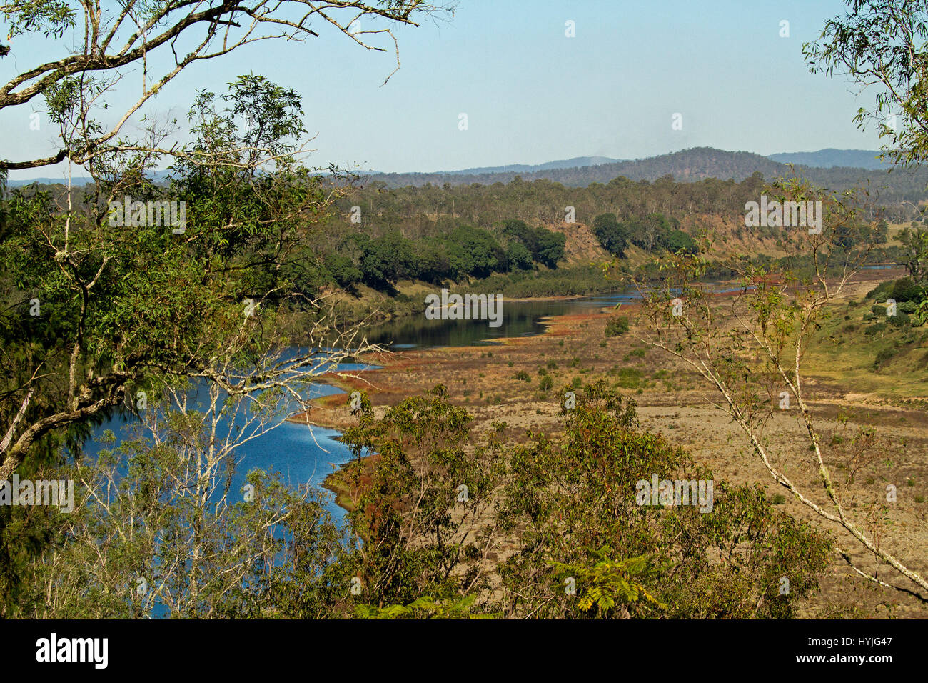 Vast Australian landscape with blue waters of Clarence River in valley hemmed by forests with peaks of ranges on horizon under blue sky in NSW Stock Photo