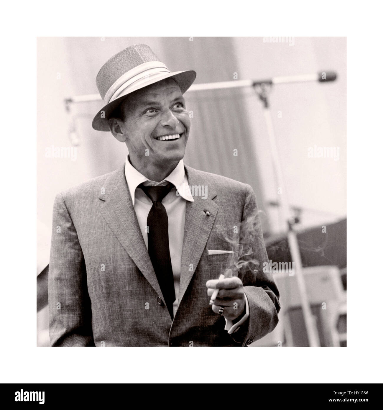 Frank Sinatra 1950's studio informal relaxed smiling promotional still image, wearing a hat smiling and smoking a cigarette in a recording studio situation Stock Photo