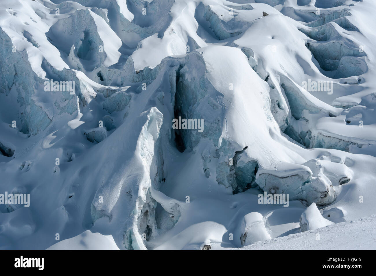 Close-up of Glacier d'Argentiere with snow covered crevasses and seracs formed while flowing down the valley in winter. Stock Photo