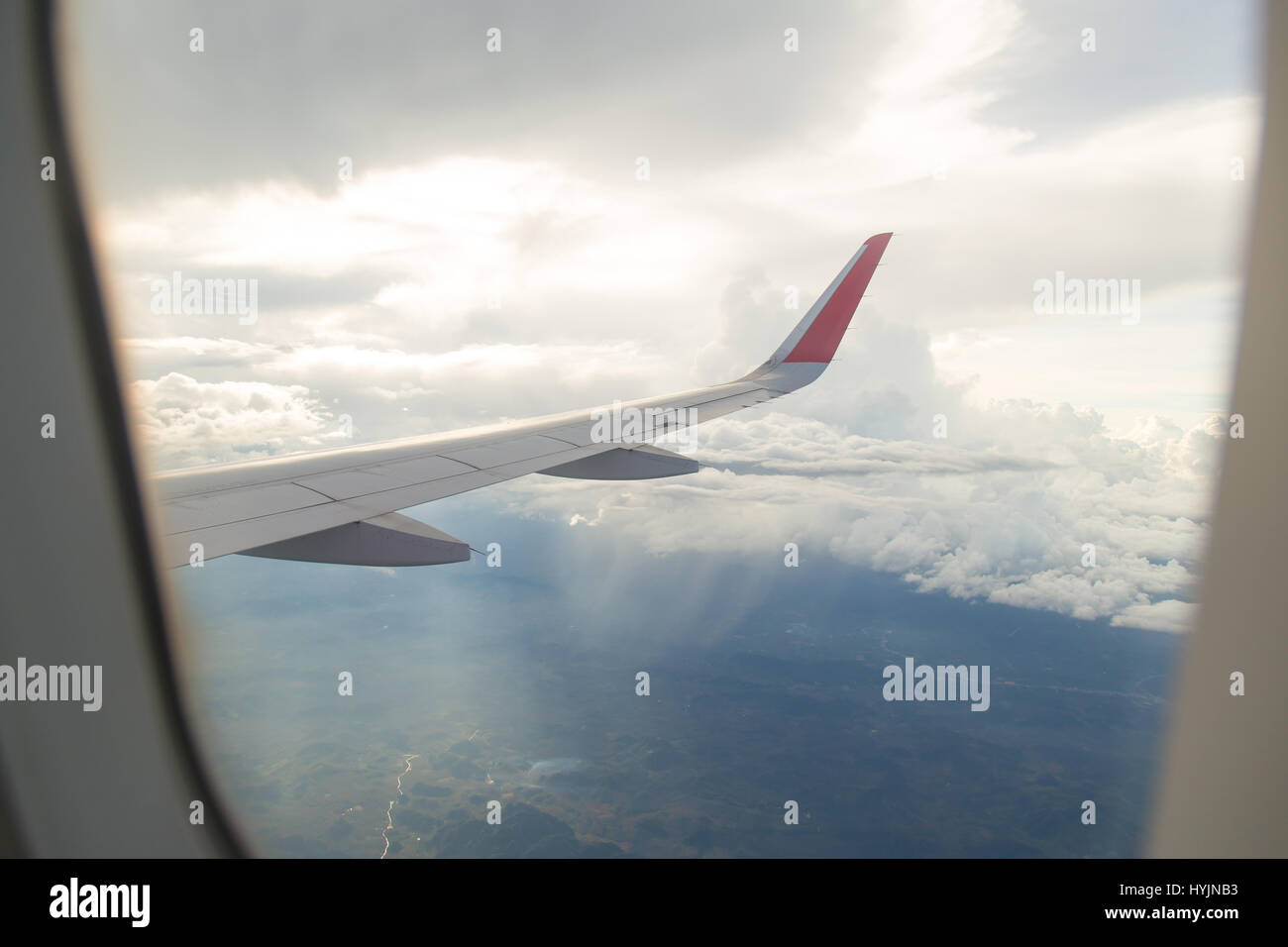 Wing of an airplane flying above the blue sky and clouds Stock Photo ...
