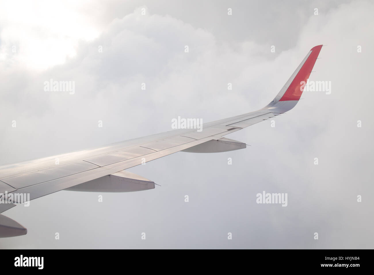 Wing of an airplane flying above the blue sky and clouds Stock Photo ...