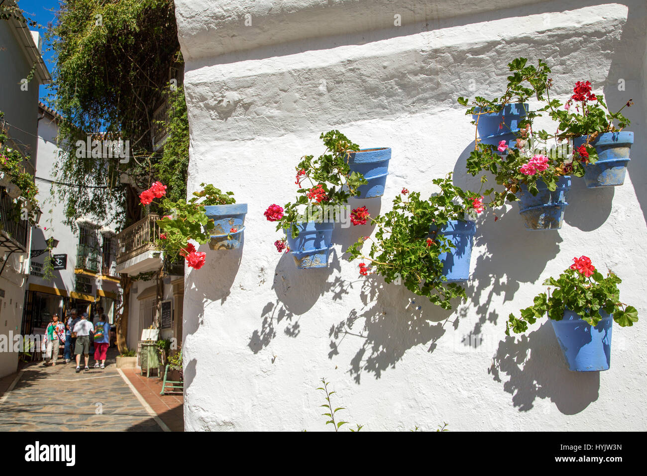 White wall with pots with flowers on a street, historic center, Marbella. Malaga province Costa del Sol. Andalusia Southern Spain, Europe Stock Photo