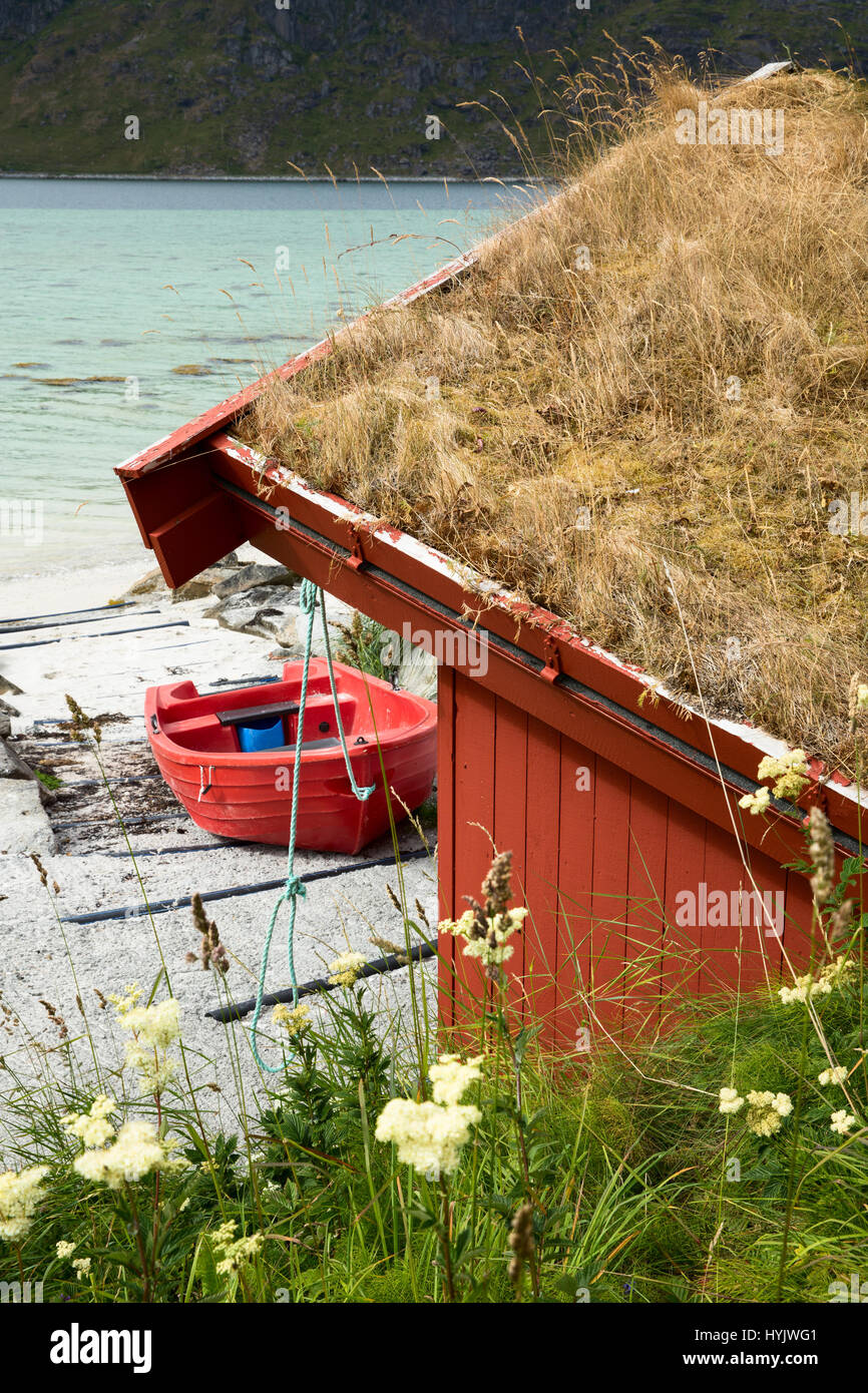 Europe,Norway,Lofoten,Flakstadoya island,a red boat near a little house Stock Photo