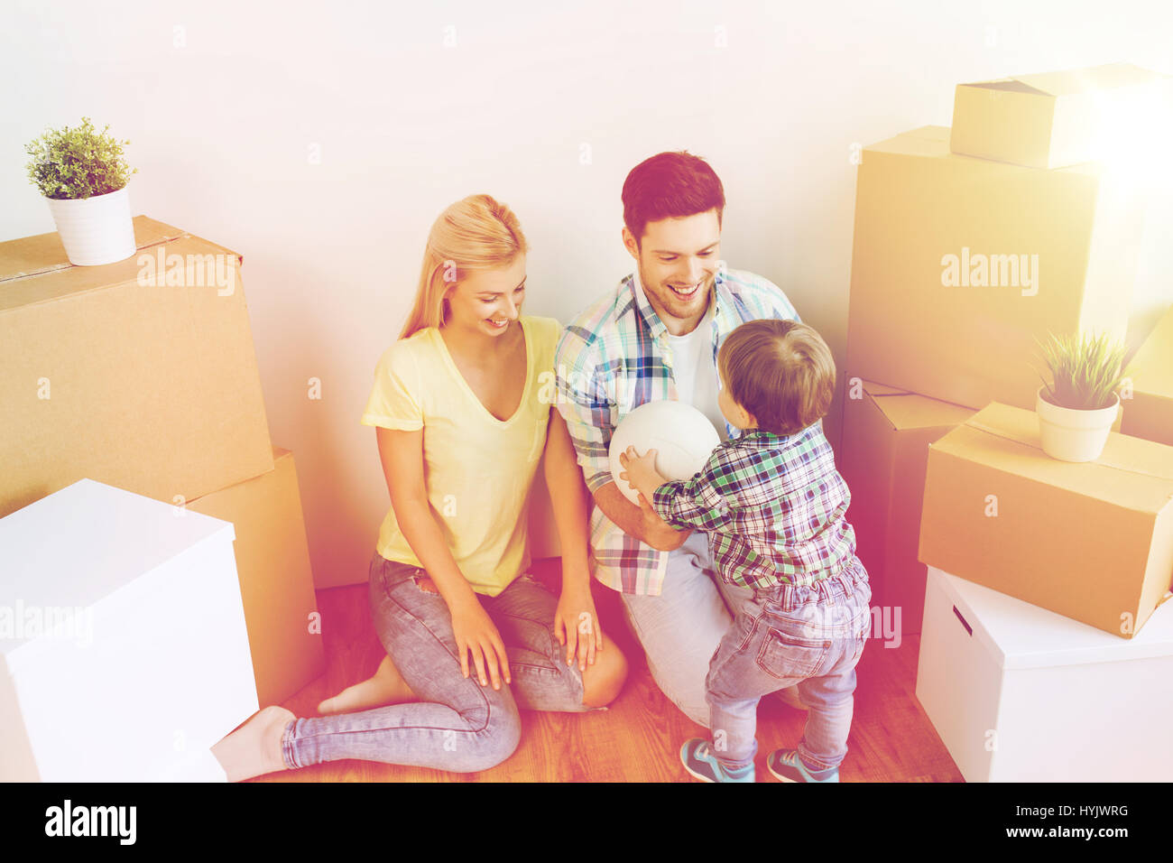 happy family moving to new home and playing ball Stock Photo - Alamy