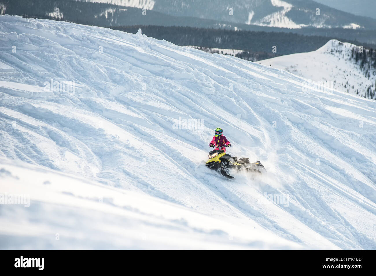 Rider on the snowmobile in the mountains . the movement of the traverse