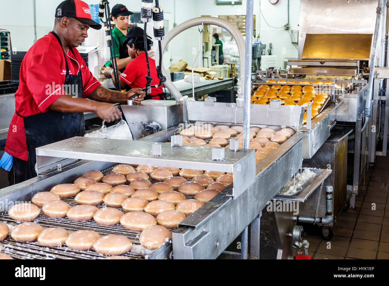 Orlando Winter Park Florida,Krispy Kreme Doughnuts,donut company,coffeehouse,production line,fryer,glazing,conveyer belt,Black man men male,working wo Stock Photo