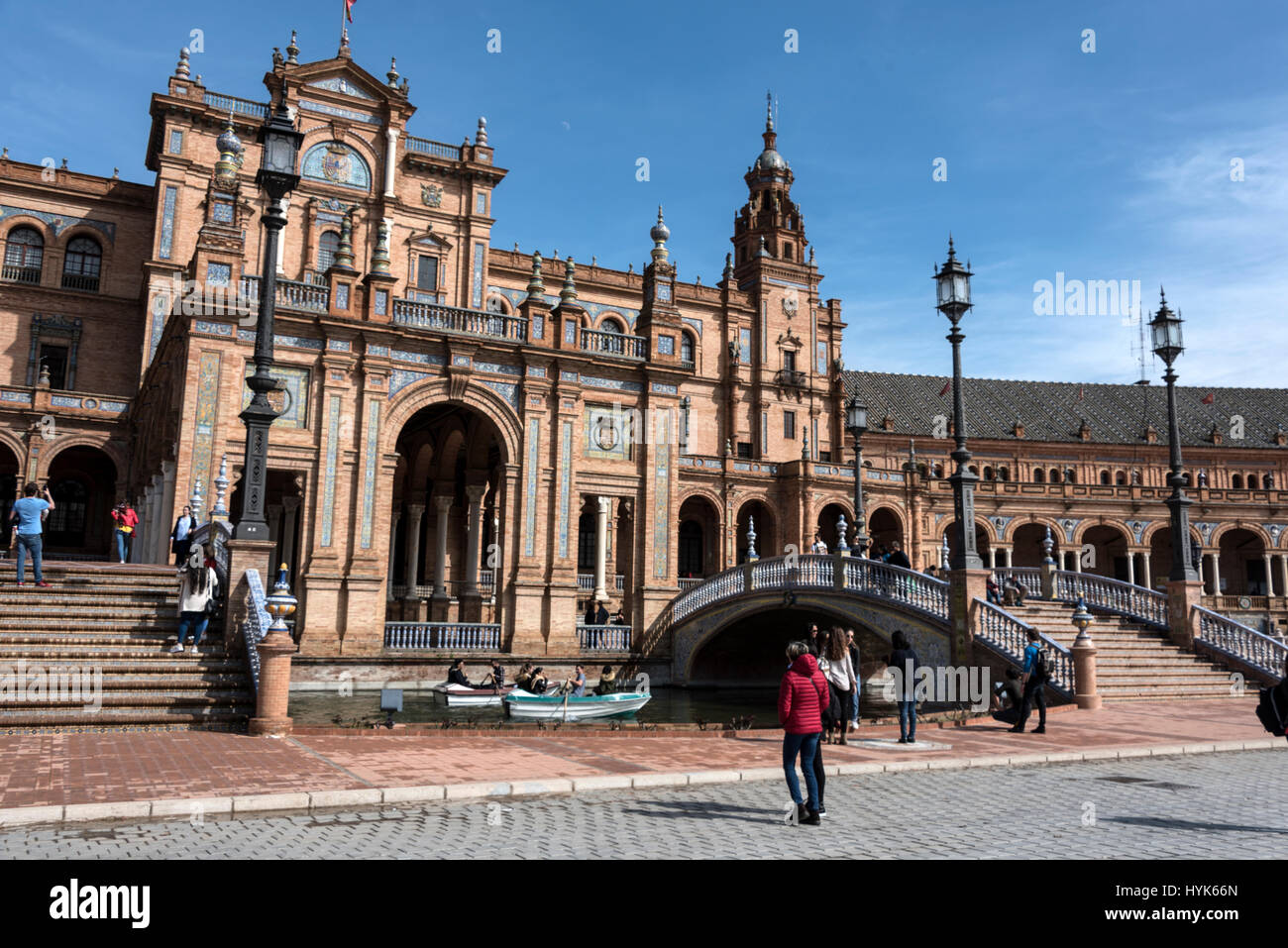 Visitors enjoying rowing small boats on a semi-circle moat with four small bridges at  the semi-circle frontage of the  Plaza de Espana, a popular ven Stock Photo