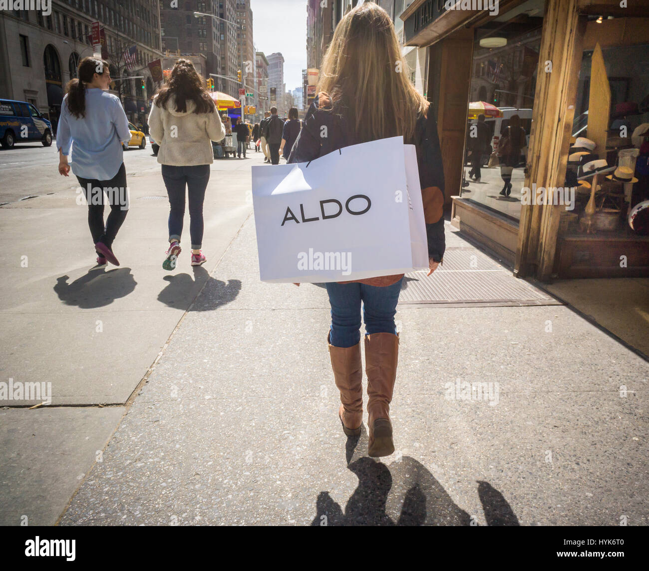 A shopper walks with a shopping bag containing her purchase from an Aldo store in New York on Monday, April 3, 2017. Aldo, a Canadian company, operates chain of almost 2,150