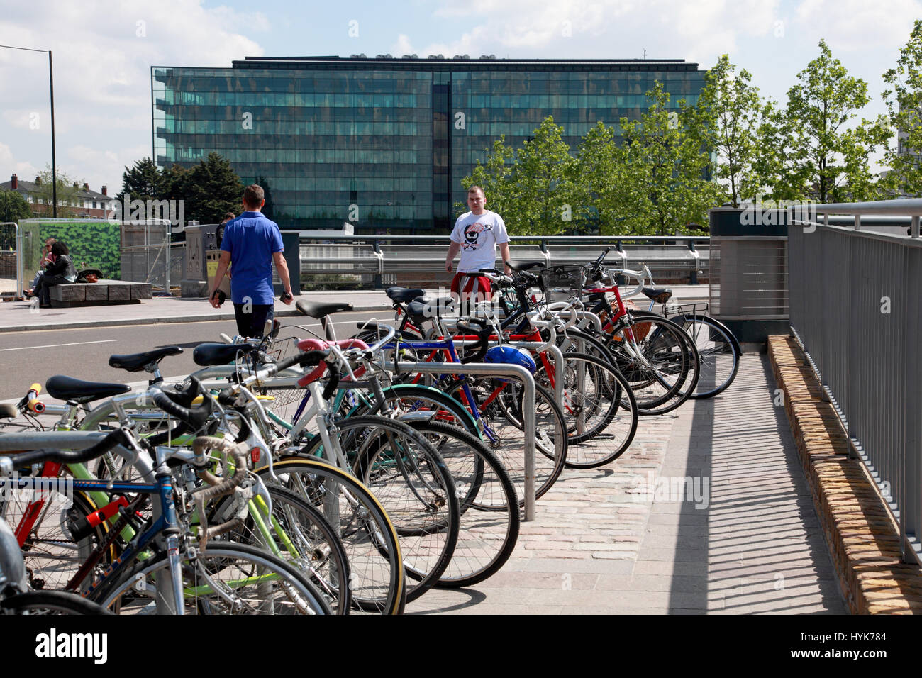 Bikes parked in Granary Square by Regent’s Canal, King’s Cross, looking towards the glass plated building, Kings Place, London Stock Photo