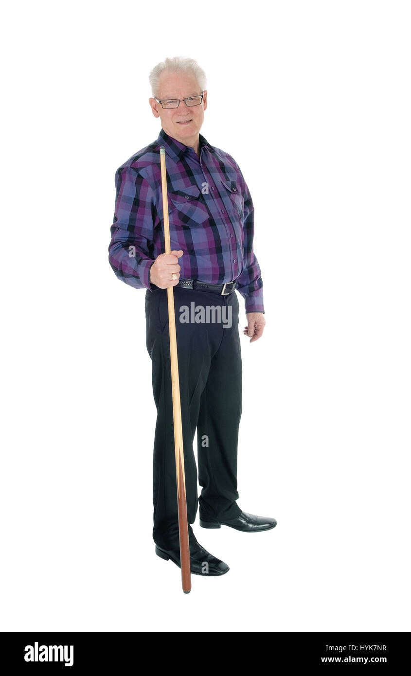 A handsome senior citizen man in a checkered shirt and jeans standing with a billiard cue isolated for white background. Stock Photo