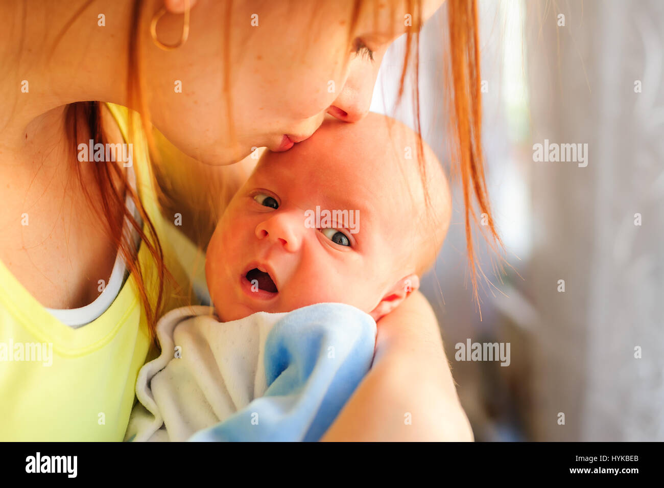Young mother kissing her little newborn baby Stock Photo