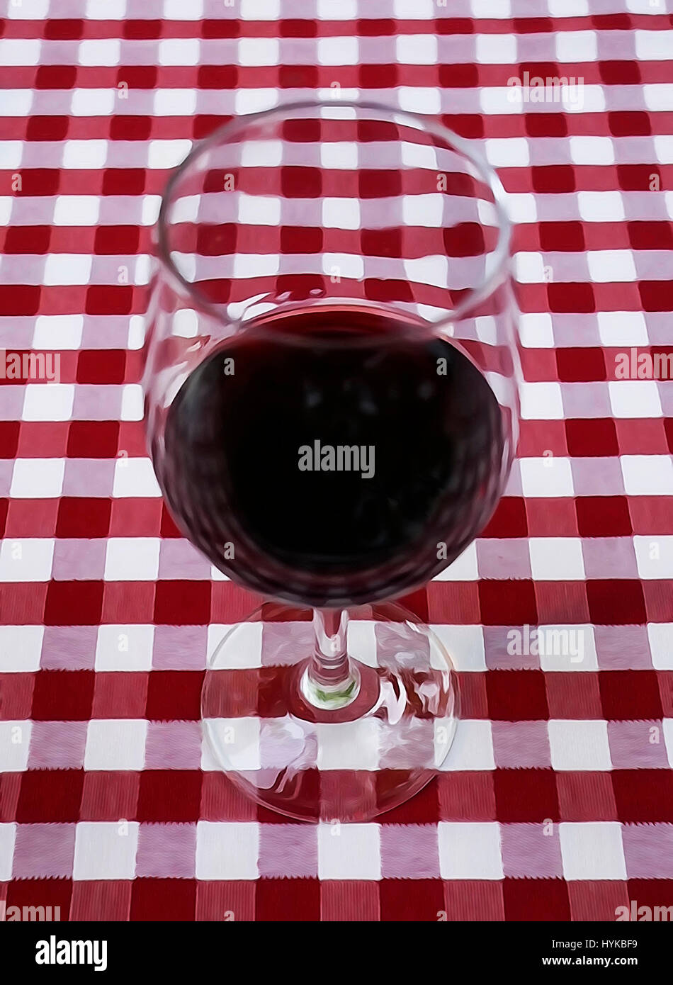 Red wine in glass on red table cloth. Stock Photo