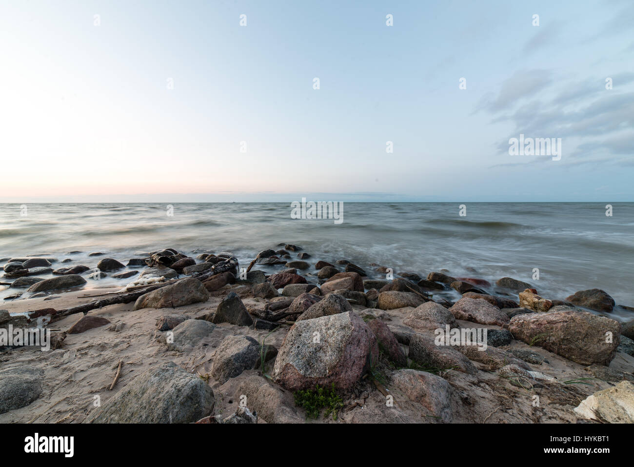 Rocky beach with clouds and water Stock Photo - Alamy