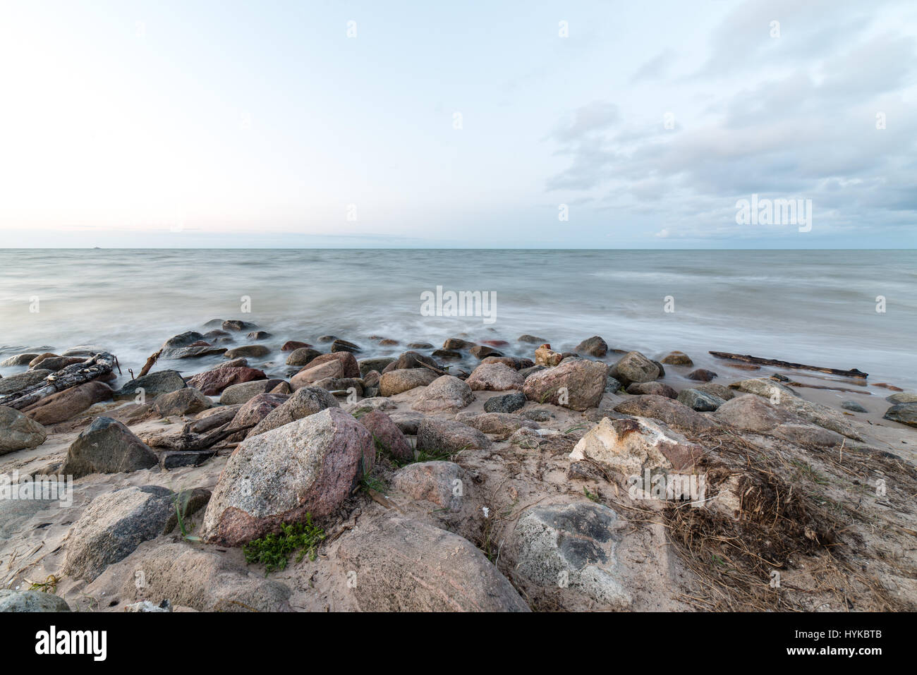 Rocky beach with clouds and water Stock Photo - Alamy