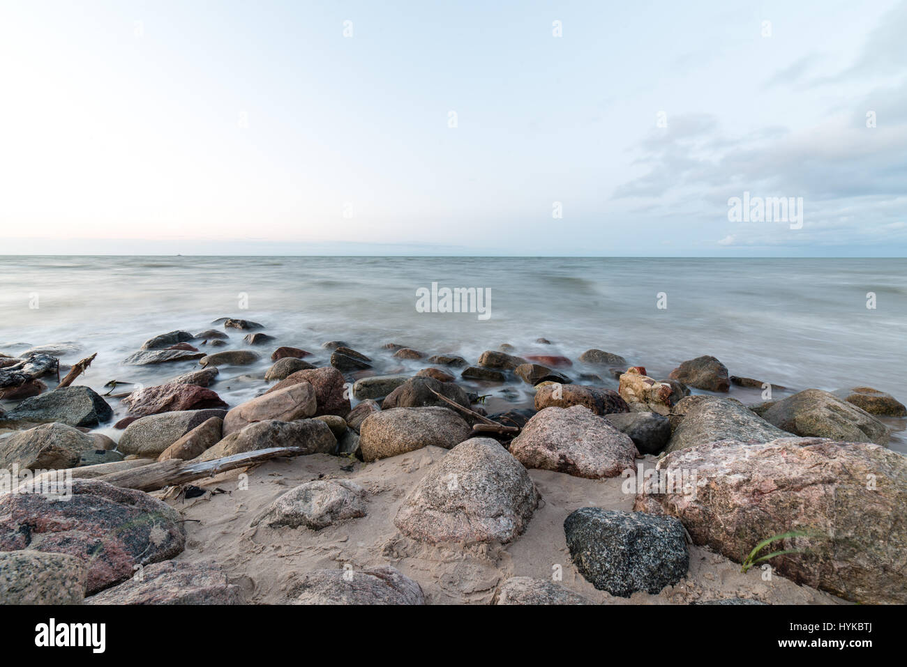 Rocky beach with clouds and water Stock Photo - Alamy