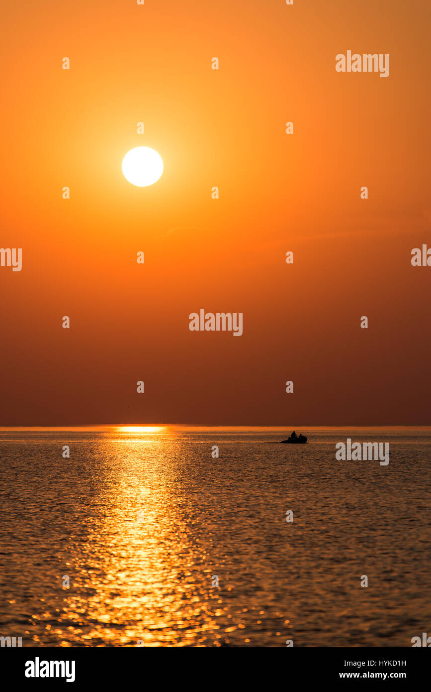 boat in the sunset in the sea with reflections and clouds Stock Photo ...
