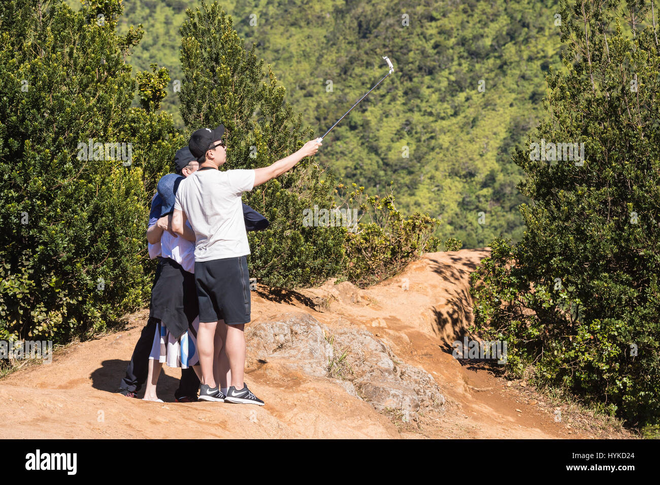 Asian tourists take selfies with scenic view, Pu'u O Kila Lookout, Koke'e State Park, Kauai, Hawaii, USA Stock Photo