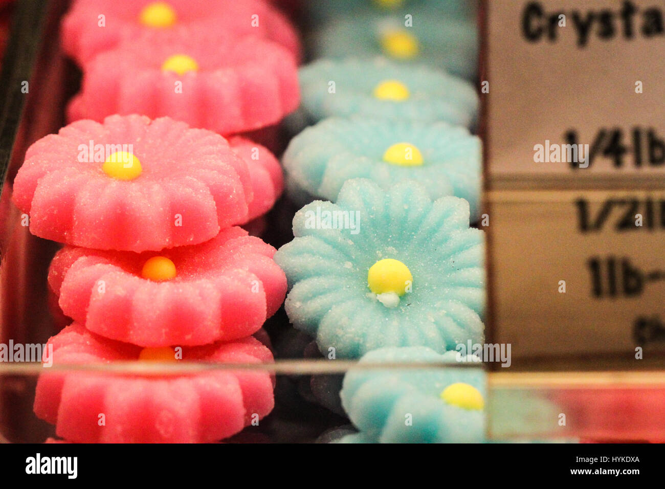 delightful pale pink and blue flower-shaped candies with yellow centers on display at a candy shop in the United States Stock Photo