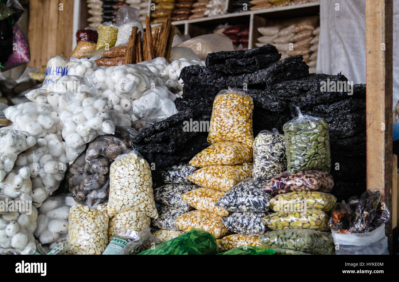 Assorted stacks of dried pulses, potatoes and seaweed on display at a market in Cusco, Peru. Stock Photo