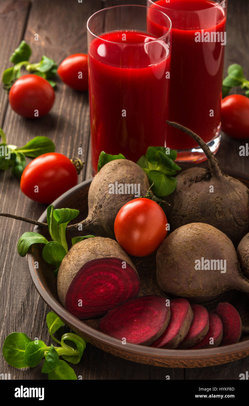 Healthy eating, dieting and vegetarian concept - glass juges of beet-tomato juice with vegetables on dark wooden background . Detox and healthy diet . Stock Photo
