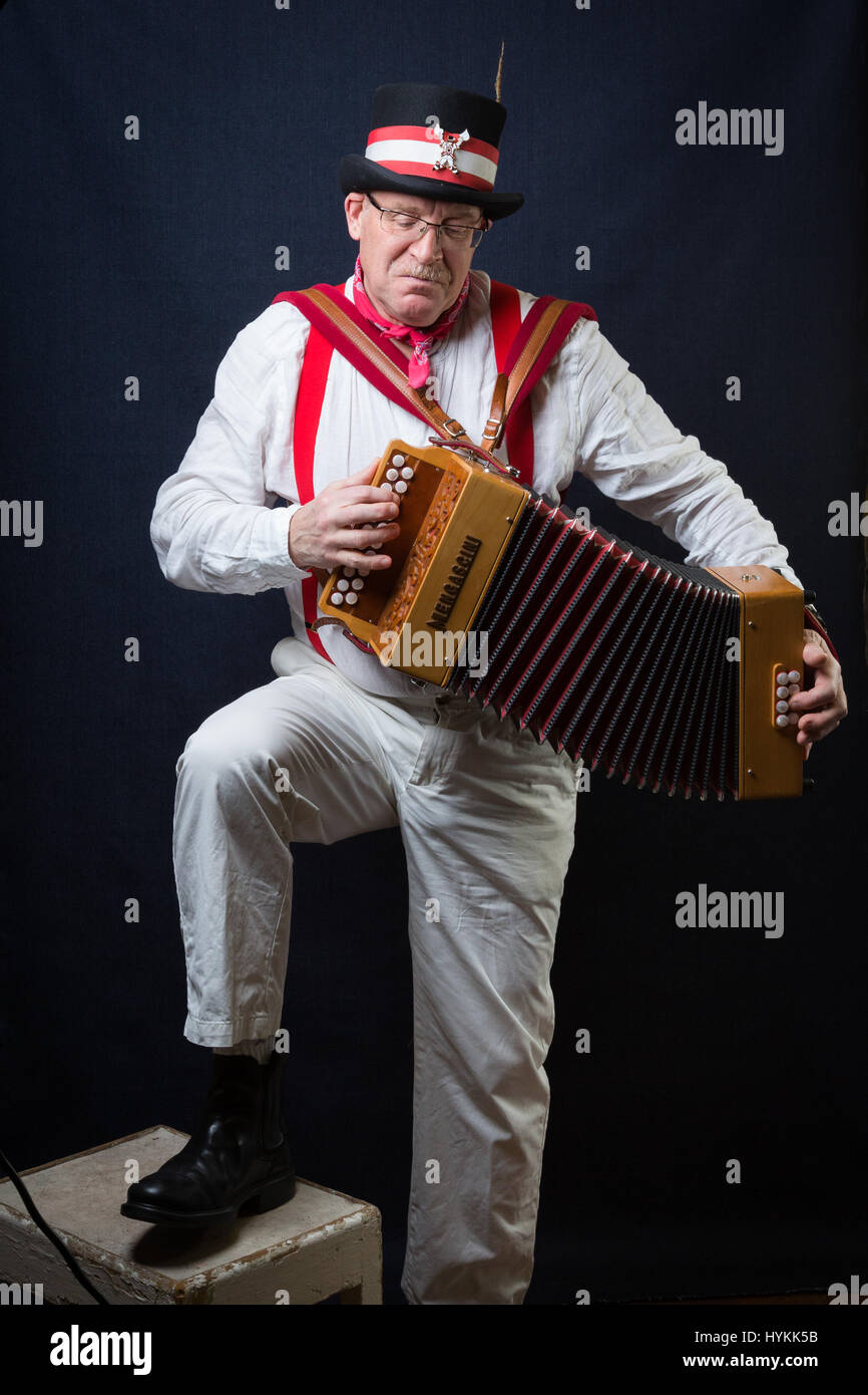 SURREY, UK: A Morris Man in traditional costume. A CELEBRATION of Britain’s finest tradition of Morris dancing men has been revealed by a Surrey resident on the most important day of the tradition May Day. Pictures show the various ages and costumes of this troupe of Morris dancers in intimate portraits. Red and white uniforms with bells and ribbons attached as well as top hats, sticks, accordions and fiddles accompany the dance group. Photographer Filip Jacek Gierlinski (39) invited his local troupe of Morris men to a studio set up in a church hall in Ewell, Surrey. Stock Photo