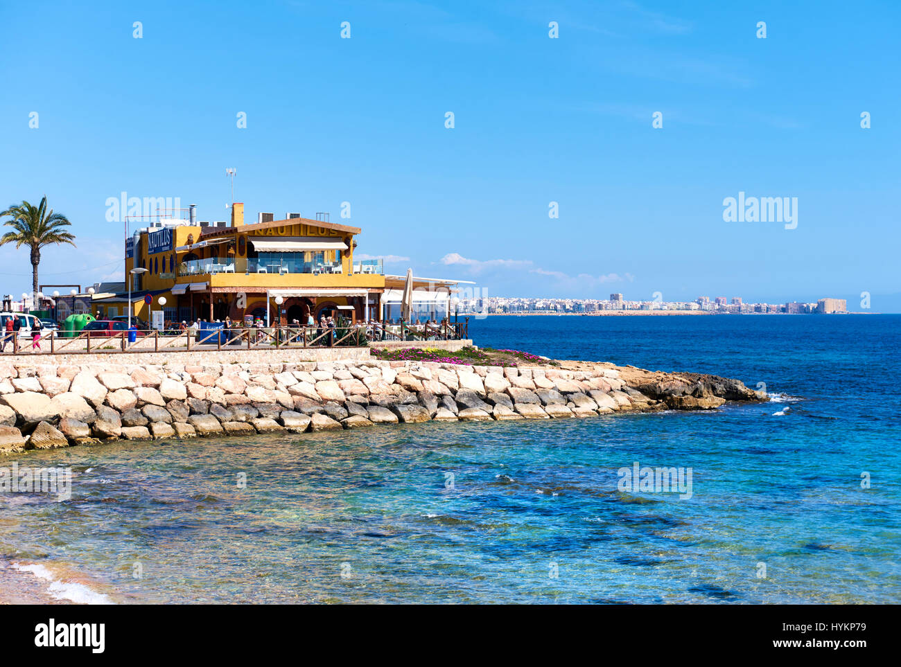 Punta Prima, Spain March 28, 2017 Tourists sitting in a seafront