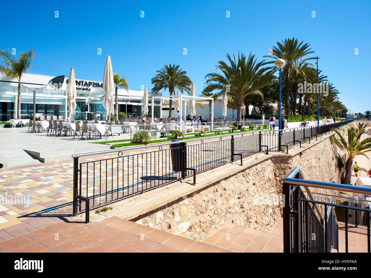 Punta Prima, Spain March 28, 2017 Tourists sitting in a seafront