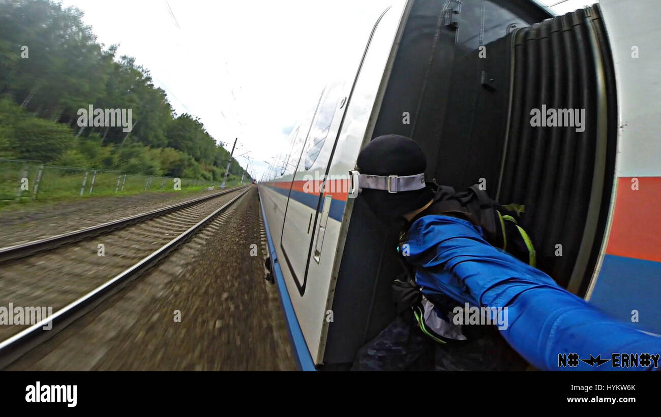 Train surfer, Alex Nomernoy hanging from the edge of a train. A ...