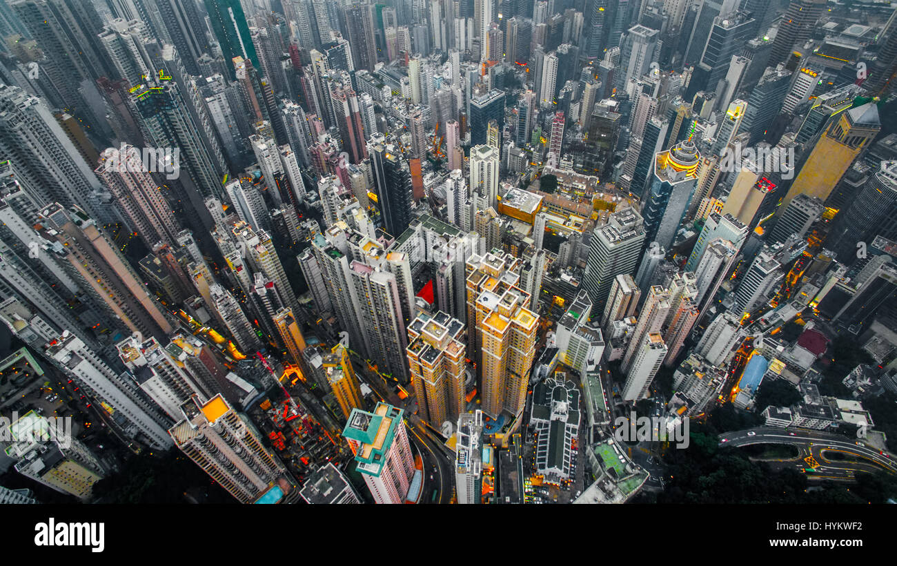 HONG KONG, CHINA: AERIAL shots taken by a drone from one thousand six hundred and forty feet in the air show the incredible clusters of skyscrapers in what is one of the world’s most dense cities. Pictures reveal a distinct lack of green space among the high concentration of multi-coloured tower blocks looking like concrete spikes darting out from the surface at varying heights. Closer inspection reveals roof gardens and connecting road networks weaving throughout the giant structures.  Other pictures show the China, DJI Phantom 3 Professional drone used to capture these airborne images. Photo Stock Photo
